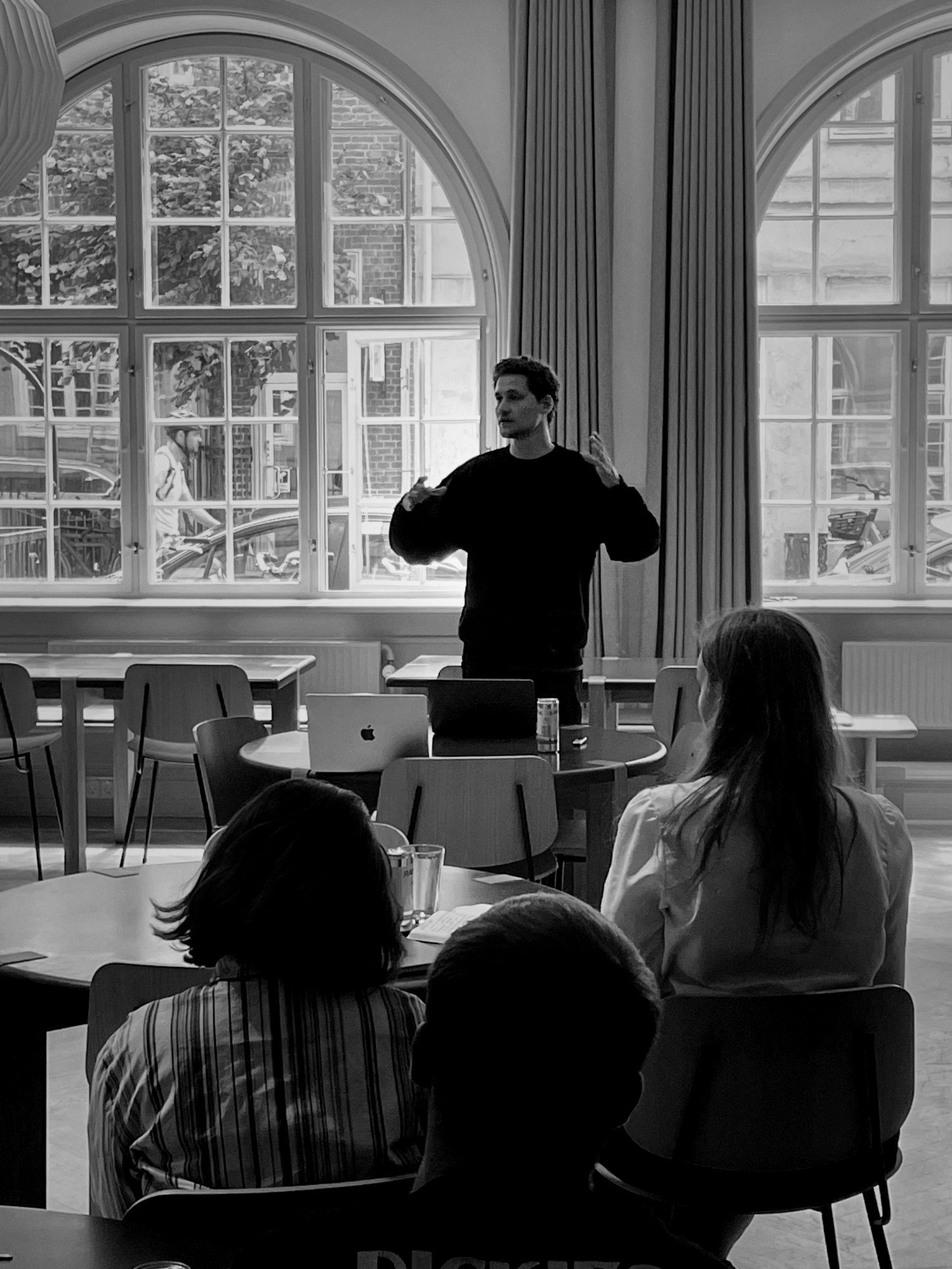 Nikolaj Dencker Schmidt underviser et team i præsentation foran store buede vinduer